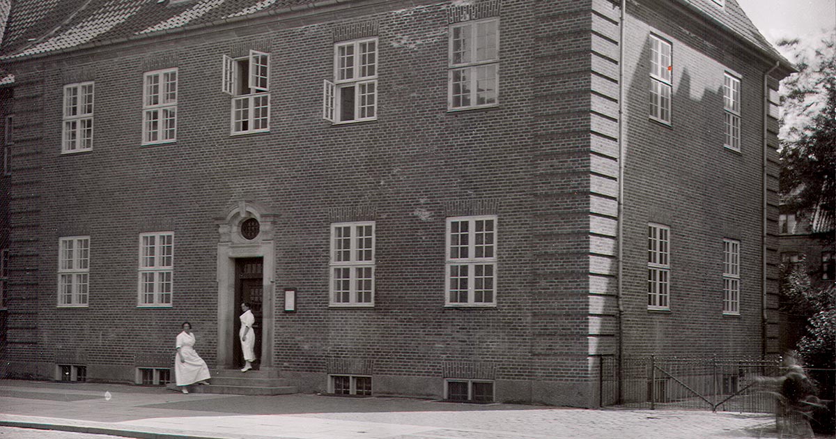 Foran indgangen til badet i Sjællandsgade står de ansatte kvinder klædt i hvide kitler. 1922 Foto: Fotograf ukendt, Københavns Stadsarkiv