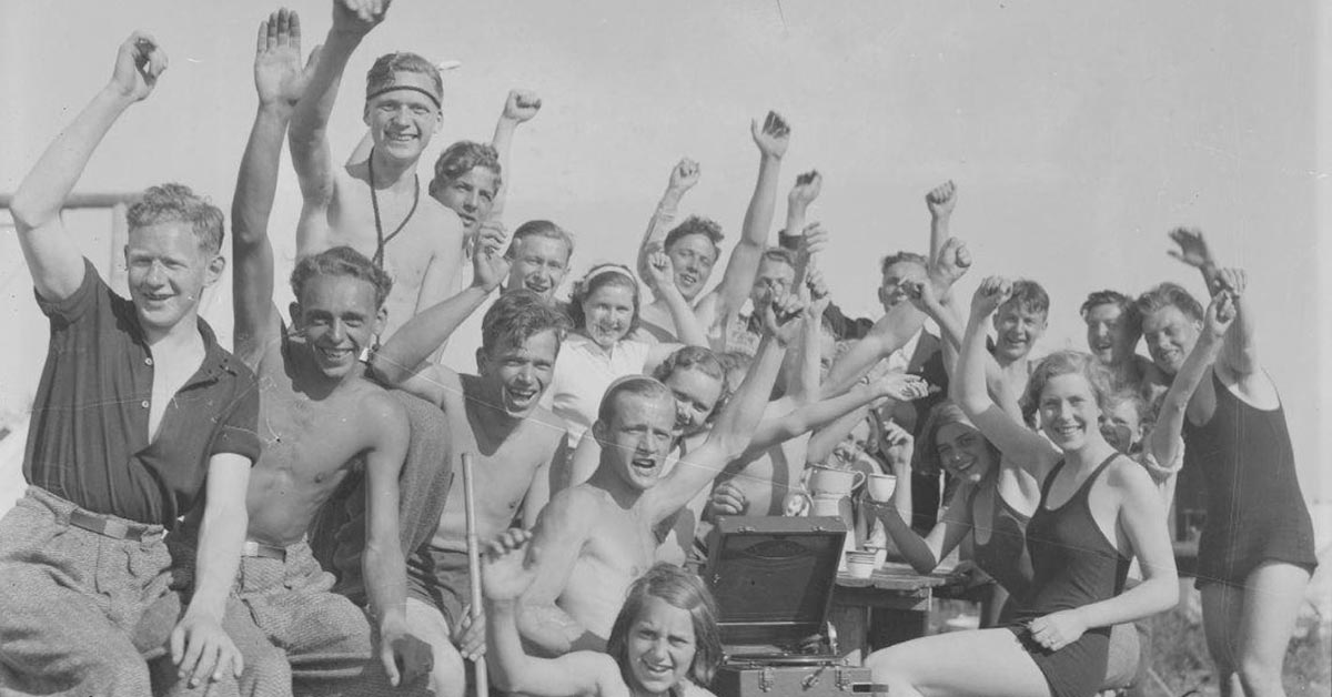 Et selskab af unge mennesker, der har indrettet sig med rejsegrammofon og primus. År: Ca. 1930-1945. Fotograf ukendt, Københavns Museum.