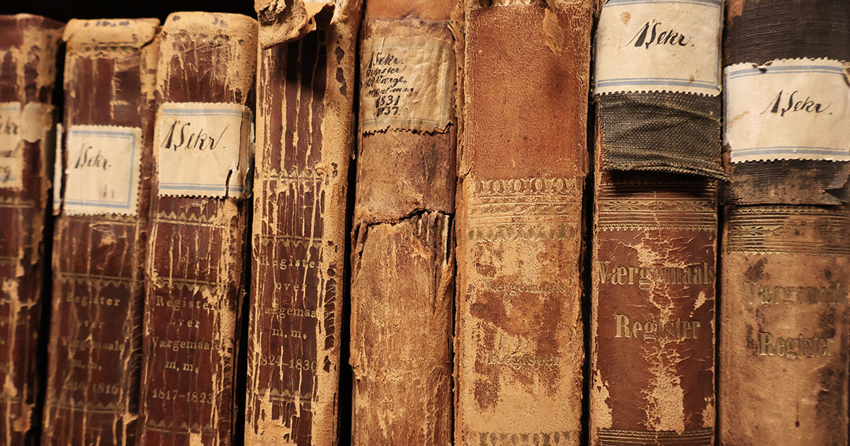 Otte slidte læderindbundne bøger på række. På bogryggene er trykt "Værgemaals Register" og påsat klistermærker med "1 Sekr."