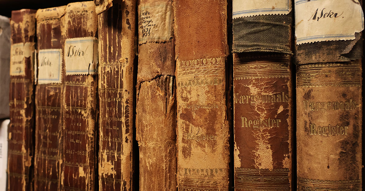Otte slidte læderindbundne bøger på række. På bogryggene er trykt "Værgemaals Register" og påsat klistermærker med "1 Sekr."